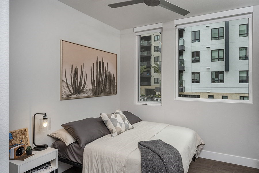 a bedroom with a bed and two windows