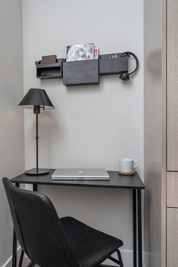 a desk with a laptop and a lamp on top of it