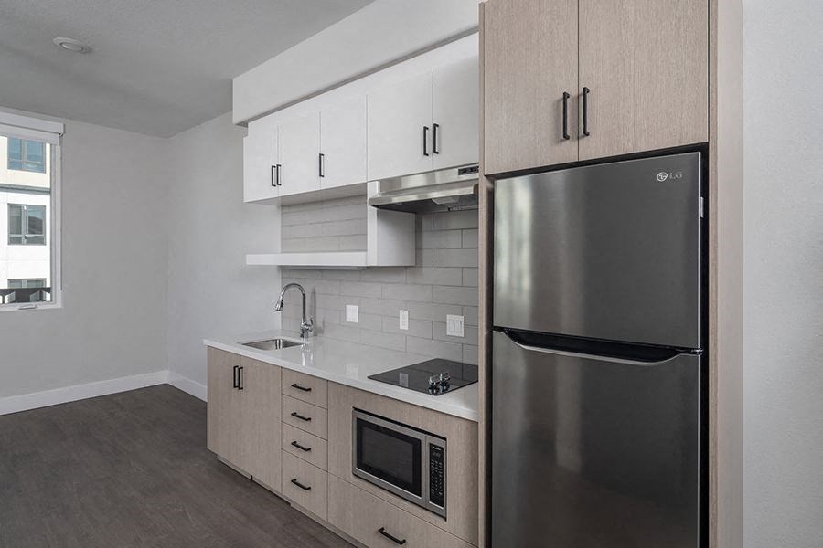 a kitchen with white cabinets and a stainless steel refrigerator
