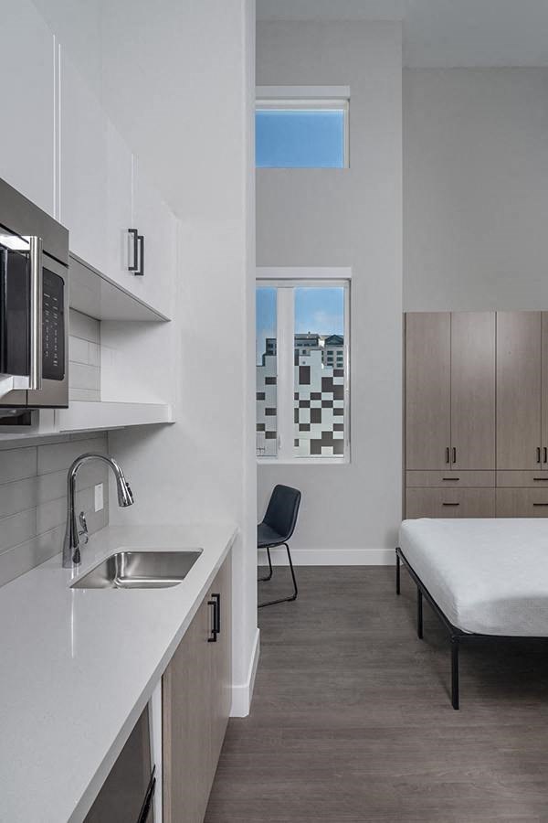 a kitchen with a sink a microwave and a window