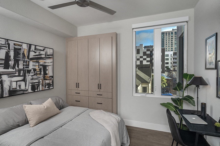 a bedroom with a bed and a desk with a chair