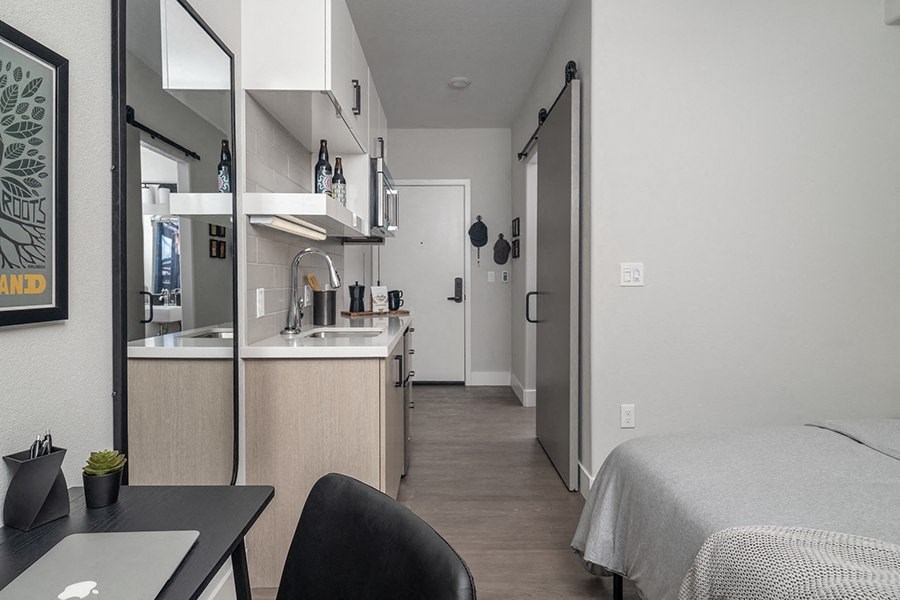 a bedroom with a bed and a desk in a room