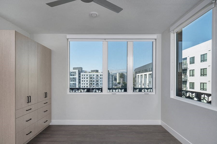a bedroom with a large window and a dresser