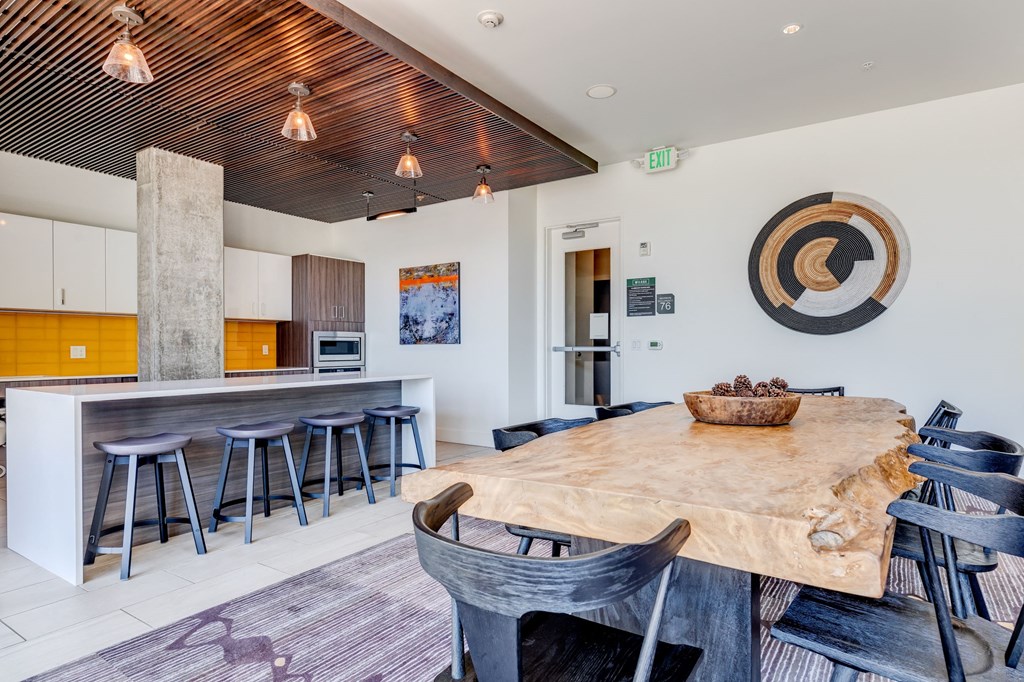 a dining area with a wooden table and chairs and a kitchen with a bar