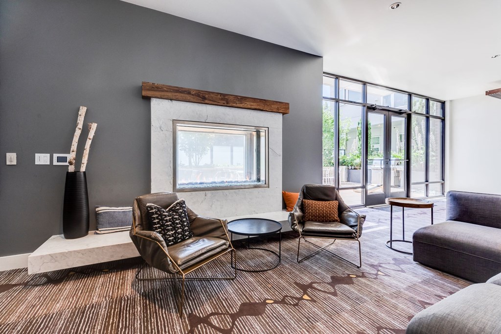 a living room with couches chairs and a fireplace   and a large window