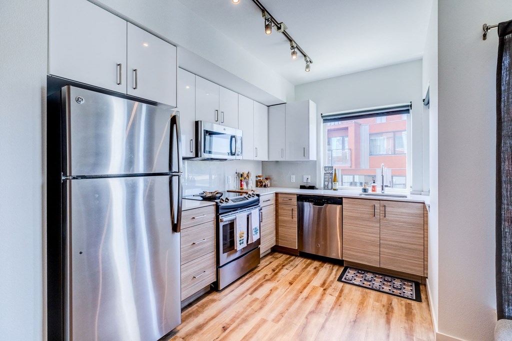 a kitchen with stainless steel appliances and white cabinets at Wilcox, Seattle, 98107
