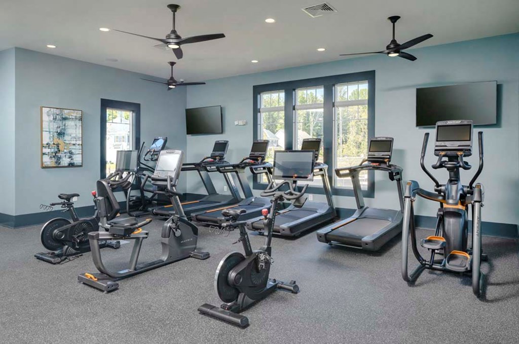 a gym with weights and a row of windows