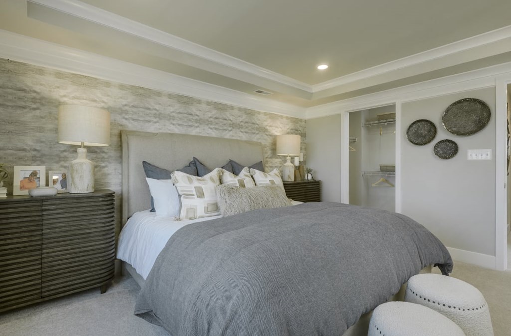 the master bedroom has a large bed and white pillows