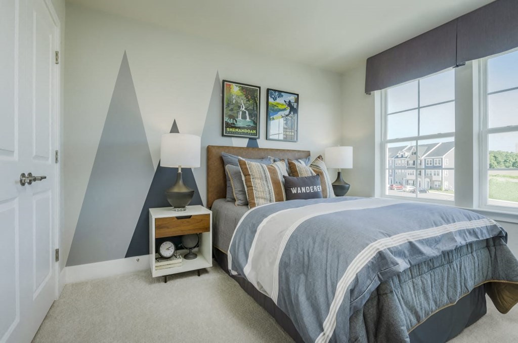 a bedroom with a bed and a large window