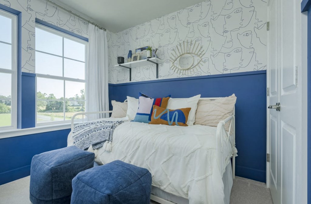 a blue and white bedroom with a bed and a window
