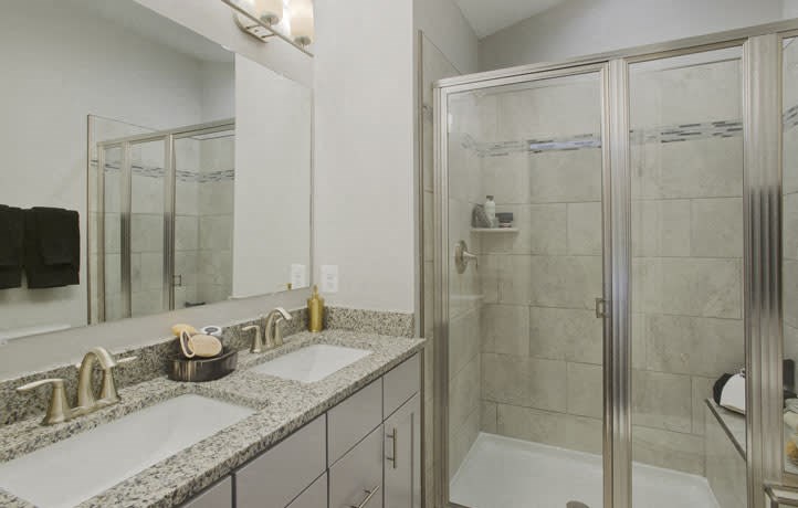a bathroom with two sinks and a shower
