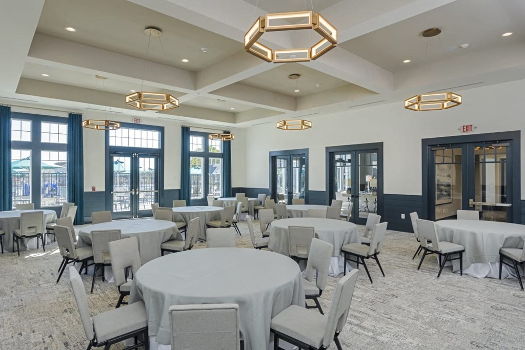 a conference room with round tables and chairs and chandeliers