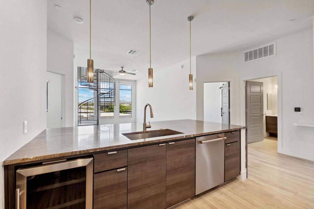 the kitchen has a large island with a sink and plenty of counter space