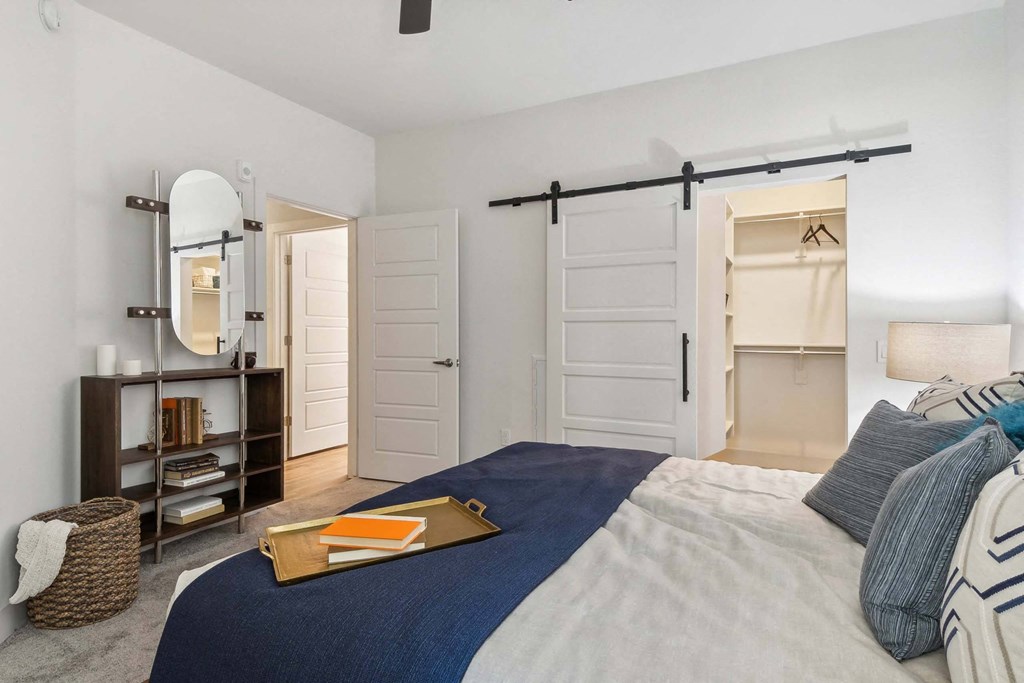 a bedroom with a large bed and a sliding door closet