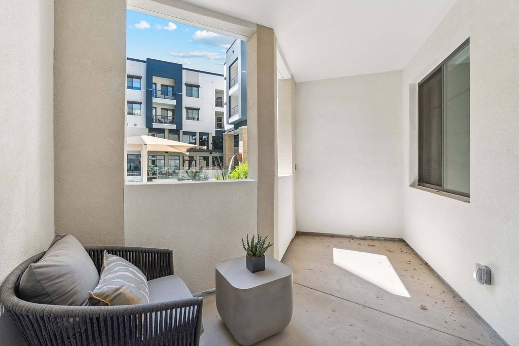 a patio with a couch and a table and a large window