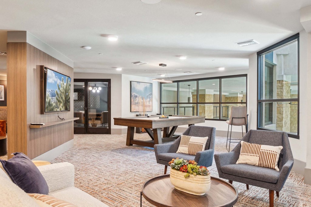 a living room with a ping pong table and couches