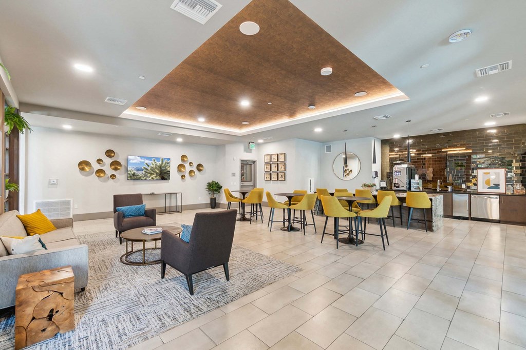 a lobby with yellow chairs and tables and a reception area