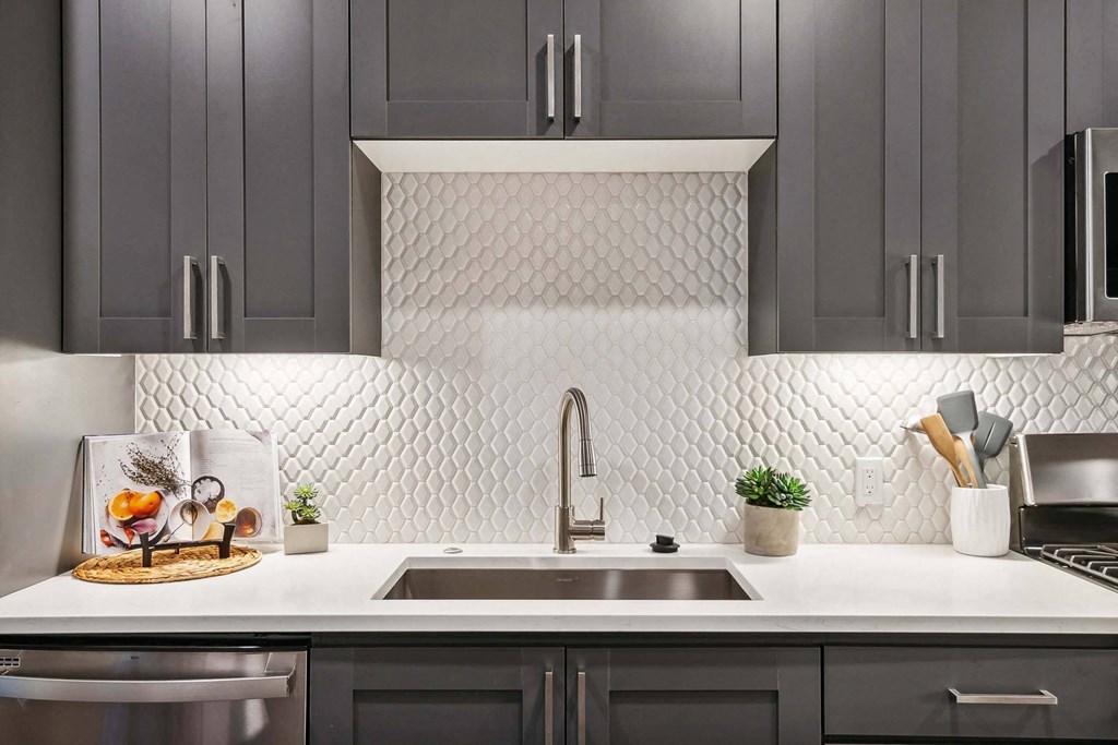 a white kitchen with black cabinets and a sink