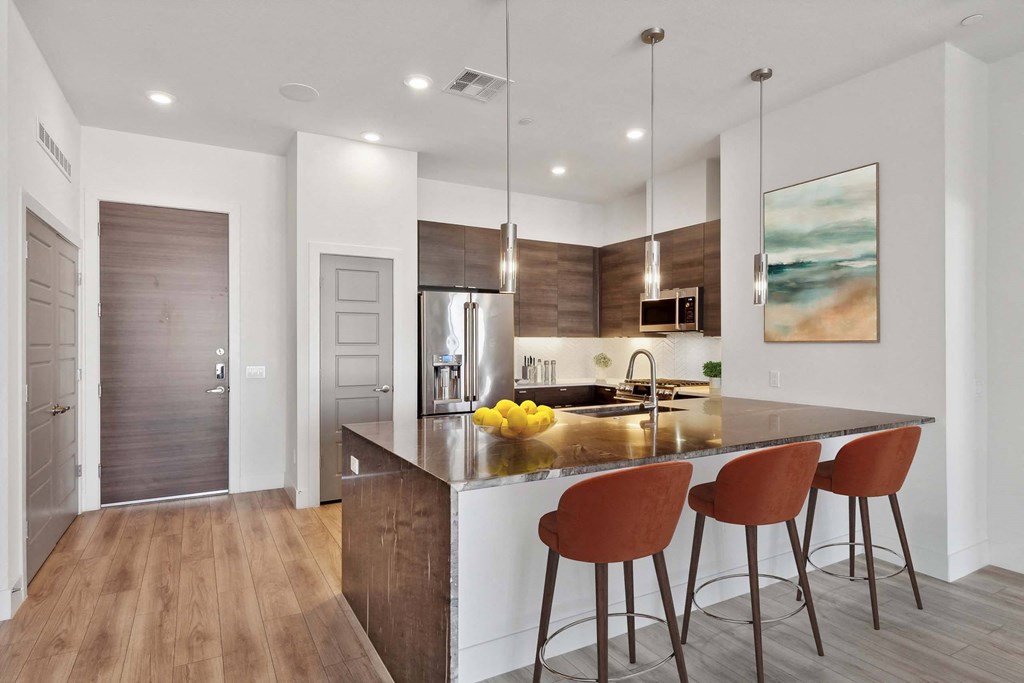 a kitchen with an island with three stools