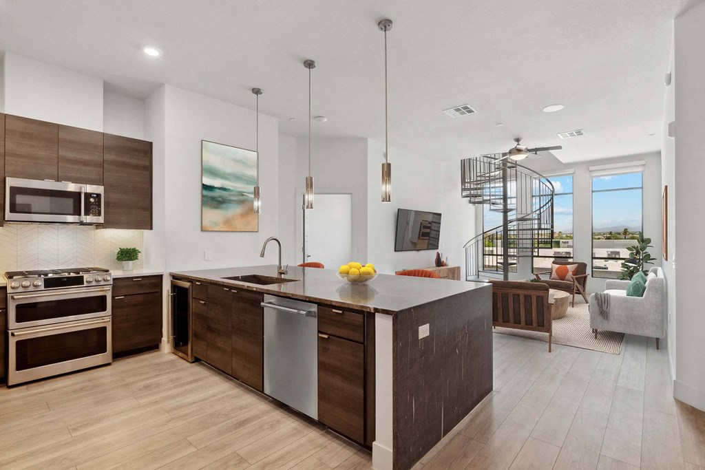 a kitchen with a large island and a living room with a staircase