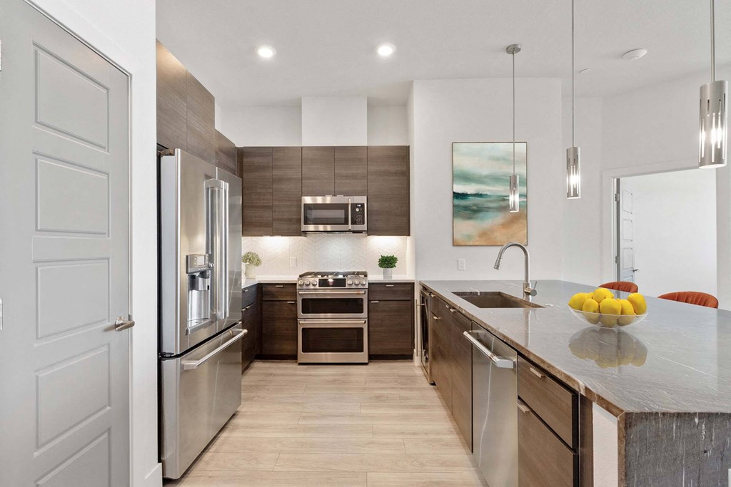 a modern kitchen with stainless steel appliances and a counter top