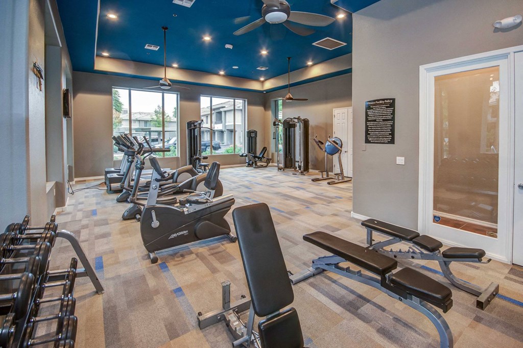 a gym with weights and cardio equipment at the estates apartments