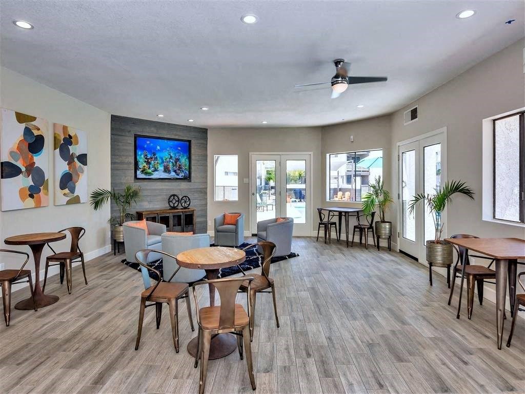 a living room with tables and chairs and a tv