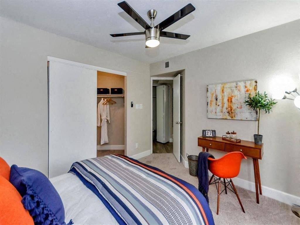 a bedroom with a bed and a ceiling fan