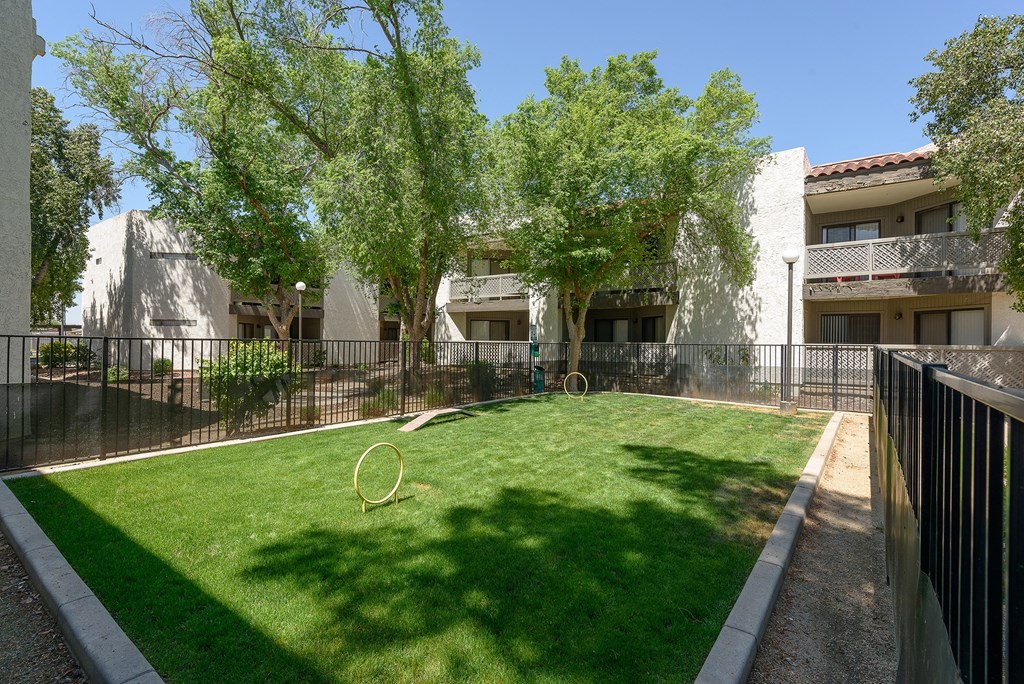 the backyard of a building with a lawn and a fence