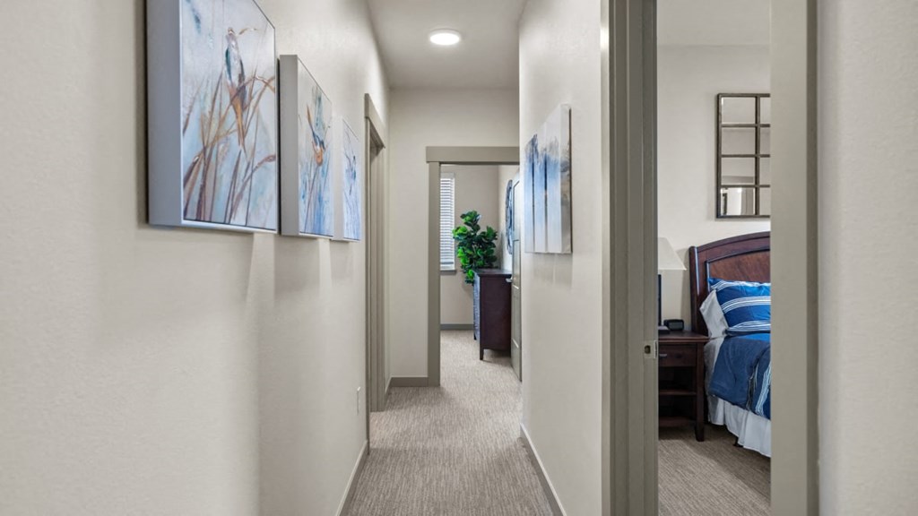 A hallway with a bedroom at the end.