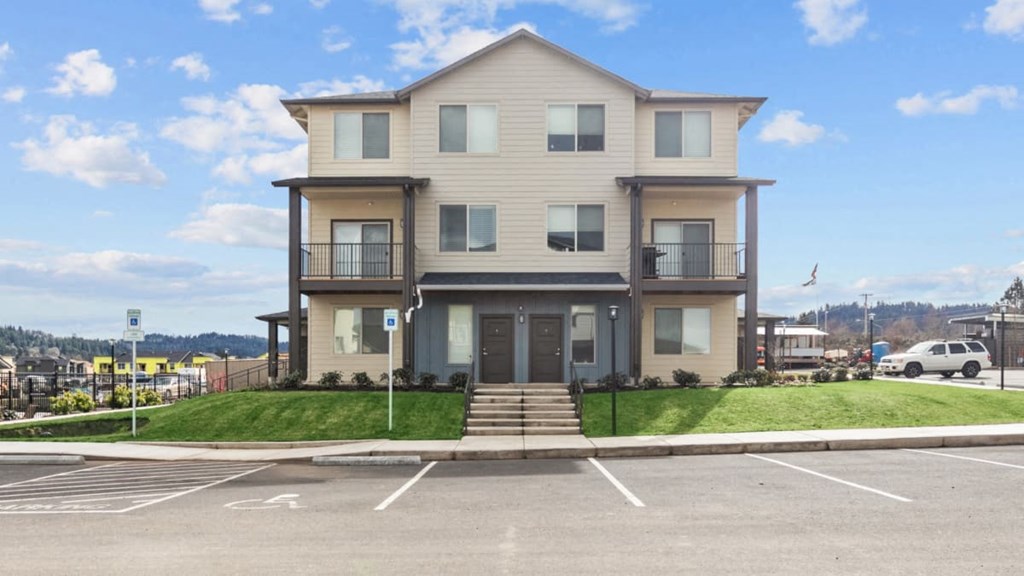 A two-story building with a parking lot in front.