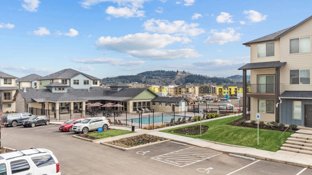 A parking lot with cars and a building in the background.