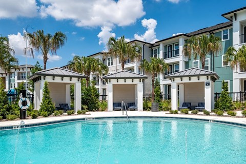A swimming pool in front of a row of apartment buildings.