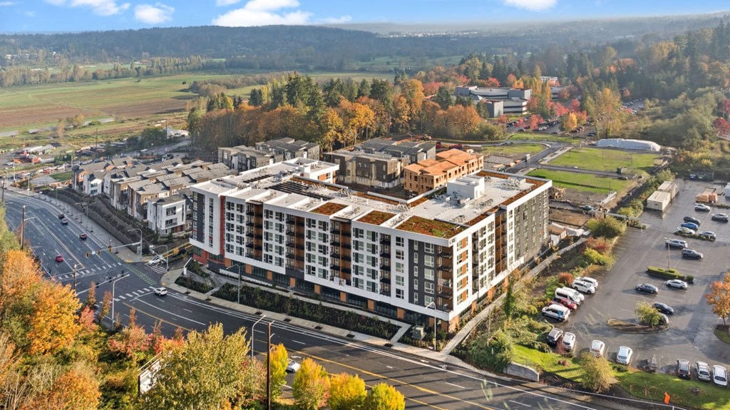 A large building with a parking lot in front of it at Cru at Willows Apartments, Redmond, WA, 98052