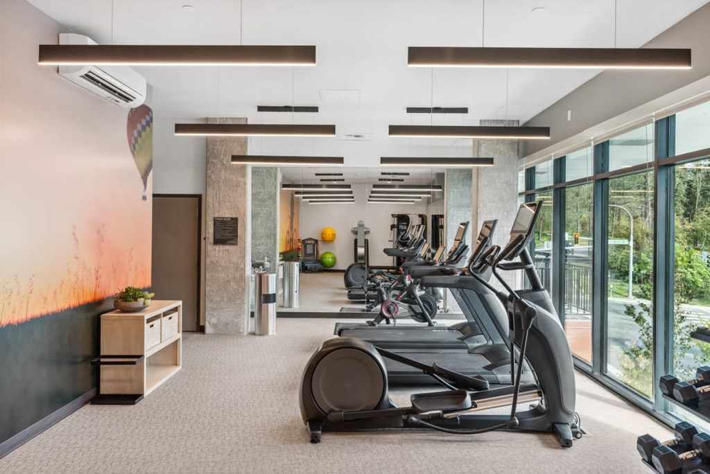 A gym with treadmills and exercise equipment at Cru at Willows Apartments, Washington
