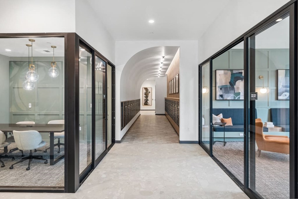 A hallway with glass doors and a carpeted floor at Cru at Willows Apartments, Washington