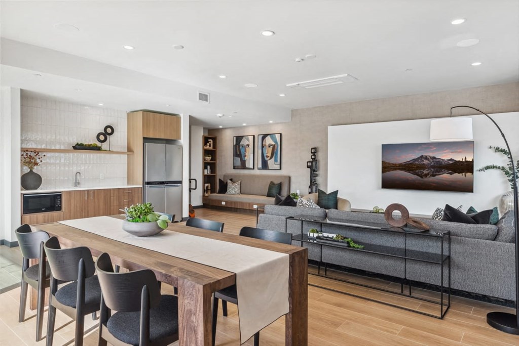 A modern living room with a wooden dining table and grey sofa at Cru at Willows Apartments, Redmond, WA