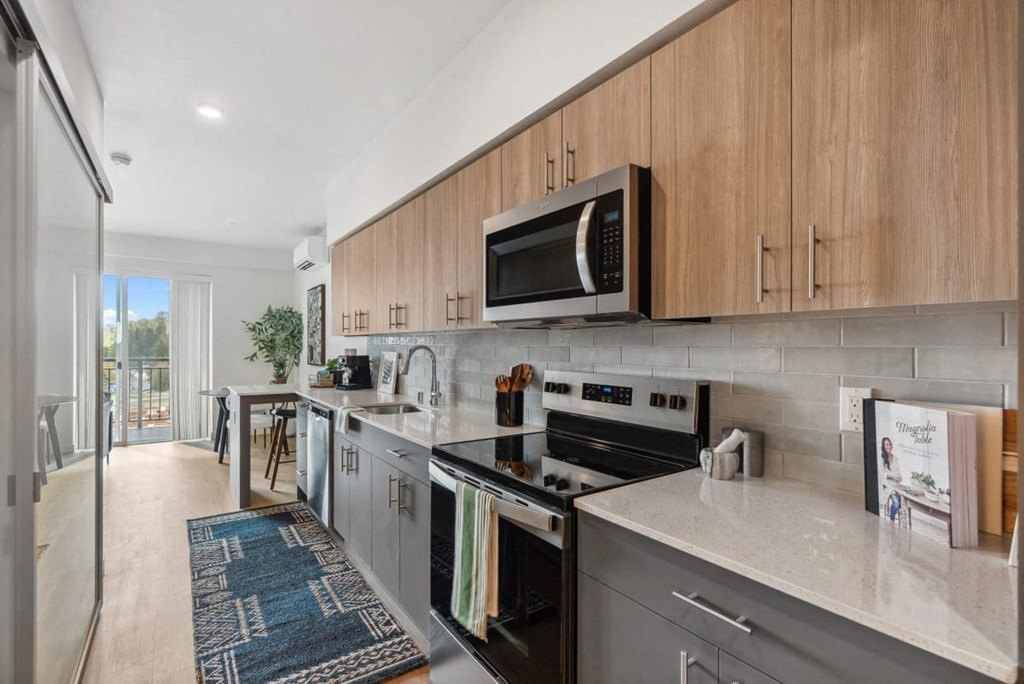 A modern kitchen with a black stove top oven and a microwave above it. A modern kitchen with a black stove top oven and a microwave above it at Cru at Willows Apartments, Redmond, 98052