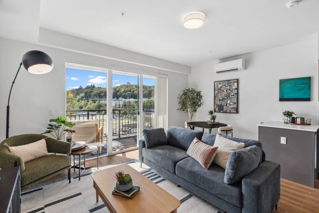 A living room with a grey couch and a wooden coffee table at Cru at Willows Apartments, Redmond, Washington, 98052