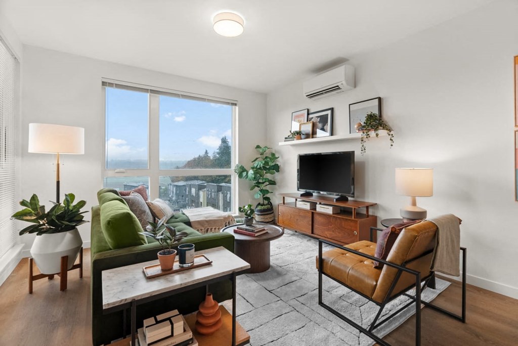 A living room with a couch, chair, and potted plants at Cru at Willows Apartments, Redmond, WA, 98052