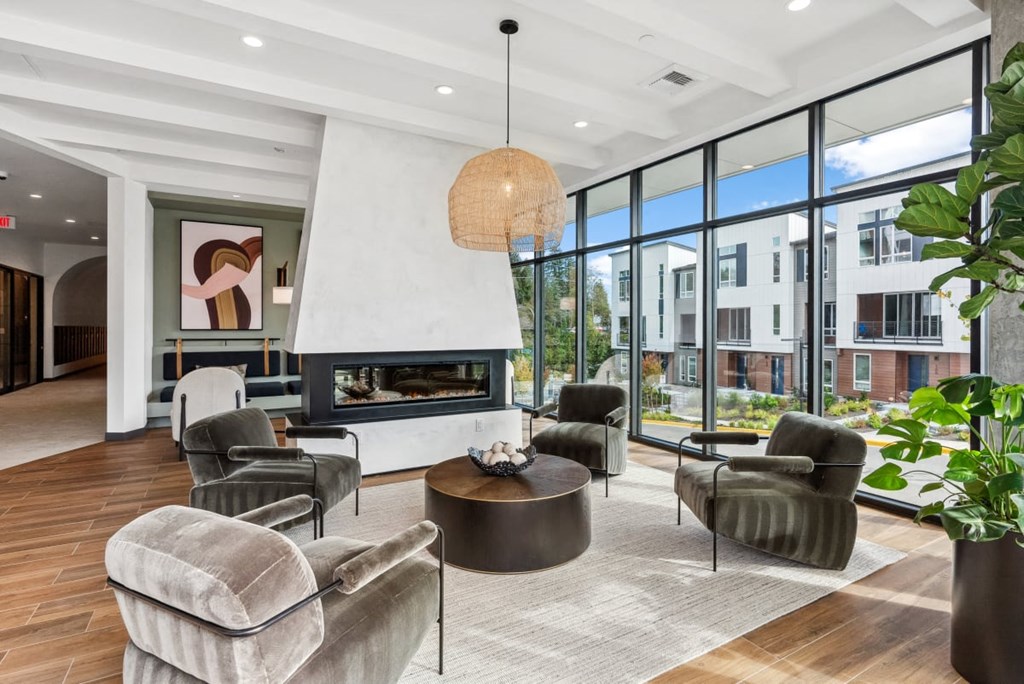 A modern living room with a fireplace and comfortable seating at Cru at Willows Apartments, Redmond, WA, 98052