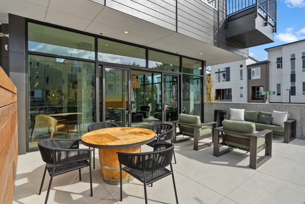 A patio with a table and chairs is shown at Cru at Willows Apartments, Redmond