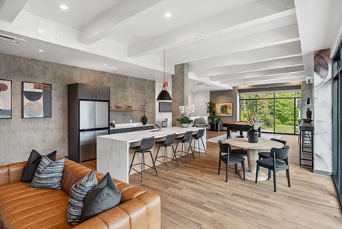 A modern living room with a brown leather sofa and a dining table with chairs.