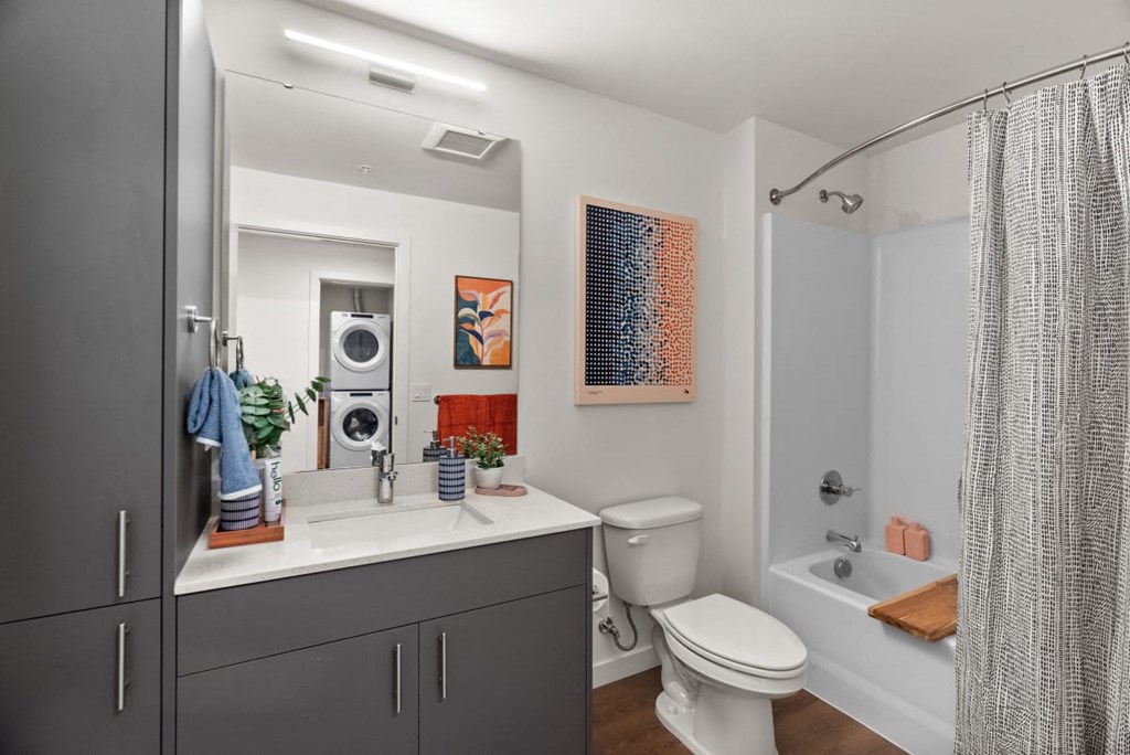 A bathroom with a toilet, sink, and shower at Cru at Willows Apartments, Redmond, WA