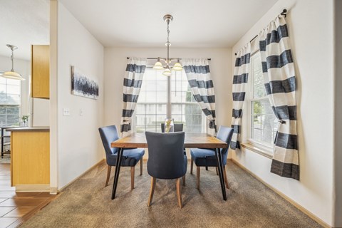 A dining room with a table and chairs.