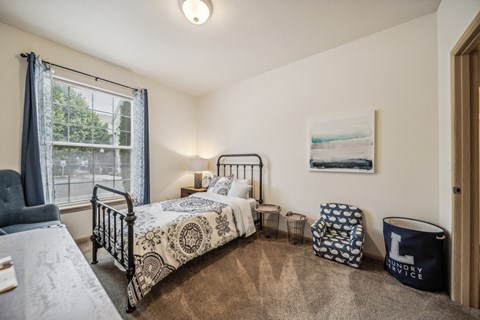 A bedroom with two beds and a chair.