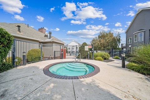 A small pool surrounded by a fence and a walkway.