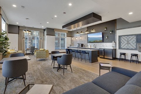 A modern living room with a grey sofa and a bar area.