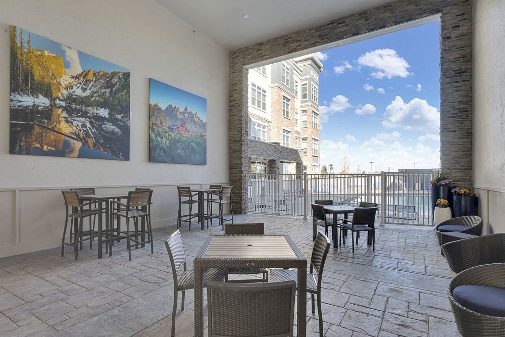 A patio with a table and chairs and a view of a building.