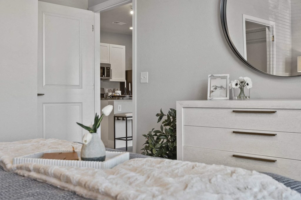 A bedroom with a bed, dresser, and mirror.